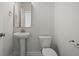 Elegant powder room with pedestal sink, toilet, and stylish mirror, complemented by neutral tones at 506 Fiskdale Cir, Summerville, SC 29486