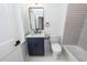 Bathroom with a soaking tub, navy vanity, toilet, and marble countertops at 24 Iron Frg Aly, Charleston, SC 29403
