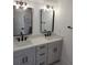 Modern bathroom features double sink vanity, black fixtures, white walls, and black framed rectangular mirrors at 24 Iron Frg Aly, Charleston, SC 29403