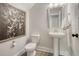 Elegant half bathroom with pedestal sink, butterfly art, and a neutral color palette at 113 O'Leary Circle, Summerville, SC 29483