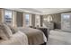 Serene main bedroom showcasing tray ceiling, three windows with curtains, and elegant decor at 113 O'Leary Circle, Summerville, SC 29483