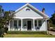 Inviting light blue home with a cozy front porch, shutters, and lush greenery enhancing curb appeal at 14 Gordon St, Charleston, SC 29403