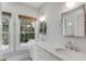 Bright bathroom featuring double sinks, marble countertops, and a large window at 517 Royall Ave, Mount Pleasant, SC 29464