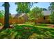 Fenced backyard featuring a lush lawn, mature trees, and a garden with a wooden bench at 125 Bramwell Dr, Summerville, SC 29485