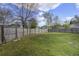 Grassy backyard enclosed by a wooden fence, showing a home's exterior and surrounding trees at 174 Education Blvd, Ladson, SC 29456