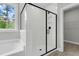 Bright bathroom featuring a glass shower door with black trim, and white tile at 357 Wappoo Trace Ln, Summerville, SC 29486