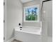 Clean bathroom featuring a soaking tub, a shower with black trim, and a view of surrounding trees at 357 Wappoo Trace Ln, Summerville, SC 29486