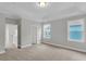 Spacious bedroom with carpet, two windows, a tray ceiling, and views into adjacent rooms at 357 Wappoo Trace Ln, Summerville, SC 29486