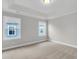Bright bedroom with neutral carpet, two windows offering exterior views, and classic trim details at 357 Wappoo Trace Ln, Summerville, SC 29486