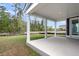 A covered back patio with tall, white pillars, a concrete floor, and a treed backyard at 357 Wappoo Trace Ln, Summerville, SC 29486