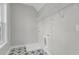 Well-lit laundry room featuring stylish tile flooring, white walls, and practical overhead shelving at 357 Wappoo Trace Ln, Summerville, SC 29486