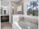 Modern bathroom with soaking tub and neutral tile at 109 Darby Meadow Ln, Ridgeville, SC 29472