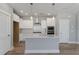 Modern kitchen with white cabinets, stainless steel appliances, a spacious island, and stylish pendant lighting for a functional design at 341 Trailmore Ln, Summerville, SC 29486