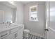 Bathroom features a window, patterned tile flooring, and a white vanity at 7038 Elm Tree Ln, Johns Island, SC 29455