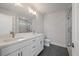 Bright bathroom features double sink vanity, large mirror, tile floors and glass enclosed shower with marble tile at 7038 Elm Tree Ln, Johns Island, SC 29455