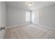 Well-lit bedroom with plush carpeting features a window and closet offering a simple, comfortable living space at 7038 Elm Tree Ln, Johns Island, SC 29455