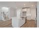 Bright kitchen features an island with sink, stainless appliances, white cabinets, and wood-look flooring at 7038 Elm Tree Ln, Johns Island, SC 29455