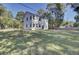 Two-story white house with a large backyard and mature trees at 5629 Ellington School Rd, Ravenel, SC 29470