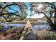 View down a private wooden dock overlooking a serene waterway with mature trees at 4415 Lord Proprietors Rd, Hollywood, SC 29449