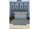 A well-lit two-car garage with a concrete driveway and a blue, two-story exterior at 3105 Sturbridge Rd, Mount Pleasant, SC 29466