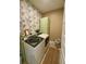 Bright and functional laundry room featuring modern washer and dryer, decorative wallpaper, and ample storage space at 3105 Sturbridge Rd, Mount Pleasant, SC 29466