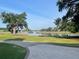 Scenic waterfront view with lush green lawn, mature trees, and a glimpse of boats on the serene water at 3105 Sturbridge Rd, Mount Pleasant, SC 29466
