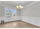 Dining room filled with natural light, showcasing hardwood floors, wainscoting, and an elegant chandelier at 709 Maynard Ln, Summerville, SC 29486