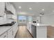 Open-concept kitchen with white cabinets, stainless steel appliances, and hardwood floors at 709 Maynard Ln, Summerville, SC 29486