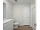 Modern bathroom with wood-look flooring, white vanity, toilet and a clear glass shower at 204 West Bradford Pointe Dr, Summerville, SC 29486