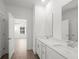 This bathroom features a double vanity, white cabinets, quartz countertop, and wood-look floors at 319 Calm Water Way, Summerville, SC 29486