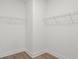 Bright walk-in closet featuring white walls, trim and shelving, and light wood flooring at 319 Calm Water Way, Summerville, SC 29486