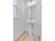 Bright powder room featuring a pedestal sink, modern fixtures, and a sleek, frameless mirror at 323 Trailmore Ln, Summerville, SC 29486