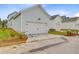 Detached two-car garage with a white door and a wide driveway surrounded by landscaping at 323 Trailmore Ln, Summerville, SC 29486