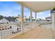 Exterior covered porch with wood decking and white railing overlooking a quiet street at 323 Trailmore Ln, Summerville, SC 29486