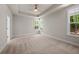 Spacious bedroom featuring a tray ceiling, a fan, carpet and large windows with trim at 244 Mcmakin Dr, Summerville, SC 29483