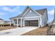 Lovely home featuring an attached two-car garage and a welcoming front porch, with a well-maintained lawn at 317 Abercom Place Dr, Moncks Corner, SC 29461