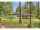 A view of the home's backyard with a covered patio and a grass area surrounded by mature pine trees at 119 Osage Way, Summerville, SC 29483