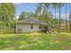 View of the home's backyard featuring a covered patio, a grassy yard, and fencing surrounded by mature trees at 119 Osage Way, Summerville, SC 29483