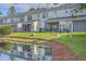 Townhome back exterior reflecting in a pond with screened in porches at 605 Pond Pine Trl, Summerville, SC 29483