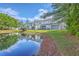 Townhome back exterior overlooking a pond with screened porches and lawn at 605 Pond Pine Trl, Summerville, SC 29483