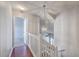 A bright hallway with hardwood floors leads to a bedroom with a view of a decorative chandelier at 605 Pond Pine Trl, Summerville, SC 29483