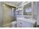 Clean bathroom with a walk-in shower, marble vanity, and floating shelves at 26 Twin Oaks Ln, Isle of Palms, SC 29451