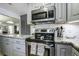 Modern kitchen with gray cabinets, stainless steel appliances, and granite countertops at 26 Twin Oaks Ln, Isle of Palms, SC 29451