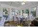 Sunroom with glass walls, ample seating and a dining table at 26 Twin Oaks Ln, Isle of Palms, SC 29451