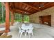 Covered patio with brick wall, ceiling fan, wood beams and tables overlooking the woods at 144 Seaton Street, Summerville, SC 29486