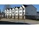New townhome construction with white exteriors, brick accents, and well-maintained landscaping at 5142 Double Eagle Lp, Summerville, SC 29485