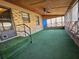 View of the sunroom with brick accents, artificial turf carpet, and screened-in frame and door at 7024 E Constellation Dr, North Charleston, SC 29418