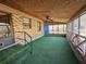 View of the sunroom with brick accents, an artificial turf carpet, and a screened-in frame at 7024 E Constellation Dr, North Charleston, SC 29418