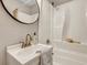 Well-lit bathroom features a shower/tub combination, a round mirror, and ample counter space at 2265 Bailey Dr, North Charleston, SC 29405