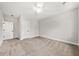 Bright bedroom features neutral carpet, a ceiling fan, and a white door leading to another room at 5874 Hwy 165, Ravenel, SC 29470